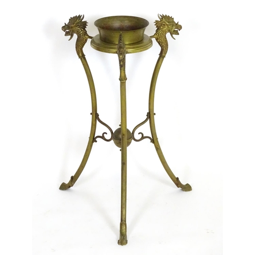 819 - A 20thC brass tripod jardiniere stand with dragon head detail. Approx. 31