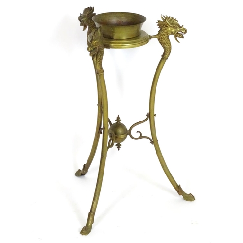 819 - A 20thC brass tripod jardiniere stand with dragon head detail. Approx. 31