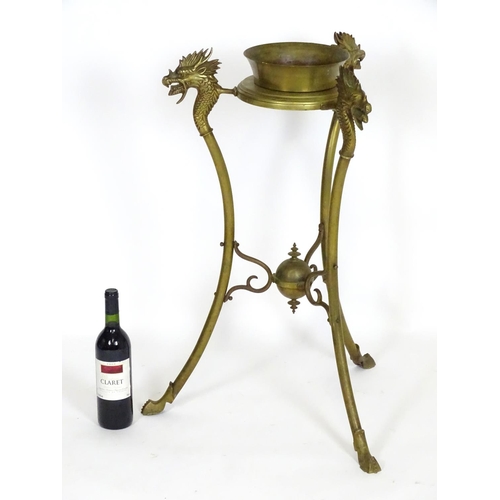 819 - A 20thC brass tripod jardiniere stand with dragon head detail. Approx. 31