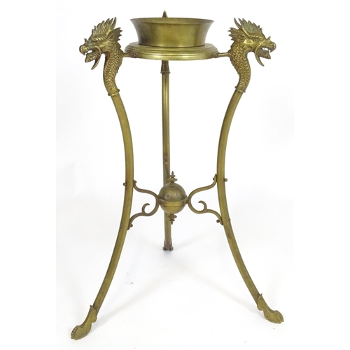 819 - A 20thC brass tripod jardiniere stand with dragon head detail. Approx. 31