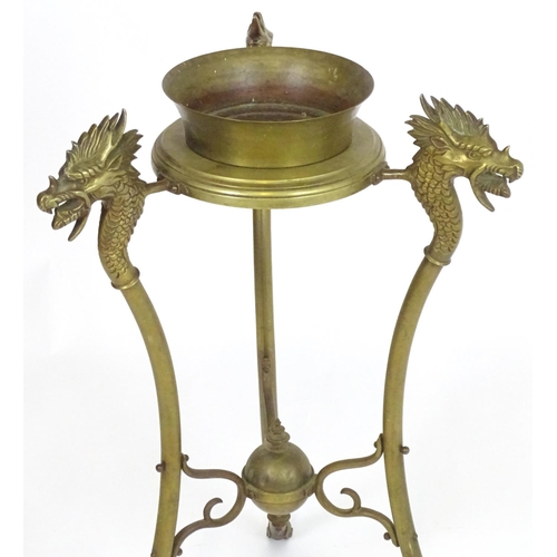 819 - A 20thC brass tripod jardiniere stand with dragon head detail. Approx. 31