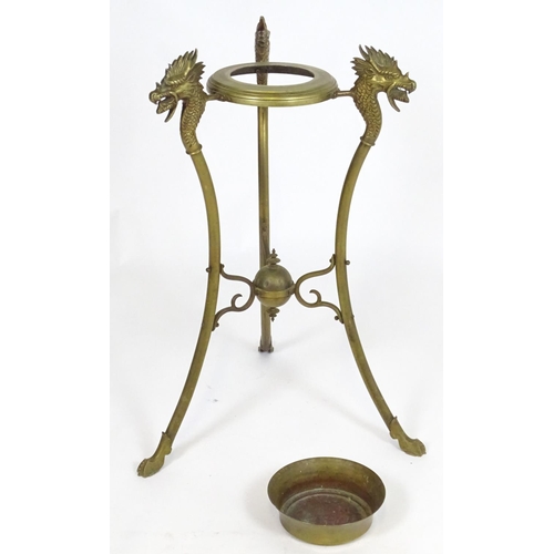 819 - A 20thC brass tripod jardiniere stand with dragon head detail. Approx. 31