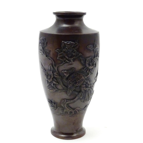 853 - An Oriental cast baluster vase with a stylised landscape scene depicting a tree, flowers and a bird ... 