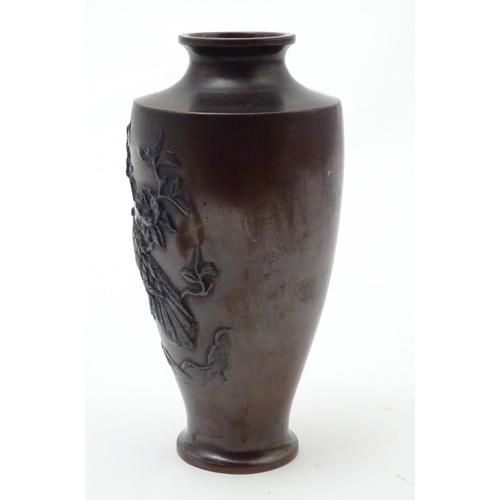 853 - An Oriental cast baluster vase with a stylised landscape scene depicting a tree, flowers and a bird ... 