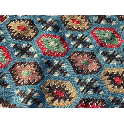 1532 - Carpet / Rug : A large Kilim rug with blue ground having geometric medallion decoration and white bo... 