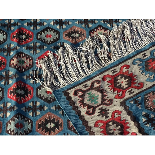 1532 - Carpet / Rug : A large Kilim rug with blue ground having geometric medallion decoration and white bo... 