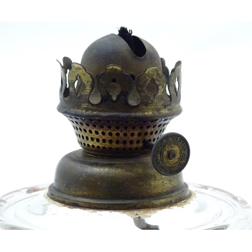 1521 - An Arts and Crafts oil lamp with cast bird decoration to the base and having facet cut clear glass r... 