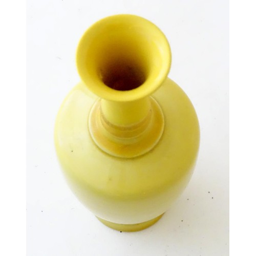 7 - A Chinese yellow glazed baluster vase with an elongated neck and flared rim. Approx. 5 3/4'' high.