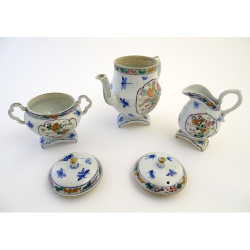 12 - A Japanese teapot, twin handled sugar bowl and milk jug decorated with hand painted insects and pane... 