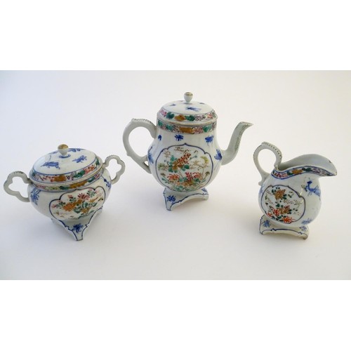 12 - A Japanese teapot, twin handled sugar bowl and milk jug decorated with hand painted insects and pane... 