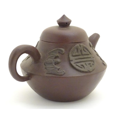 69 - Three Chinese ceramic items comprising a Yixing clay teapot, a blue and white water pot and a model ... 