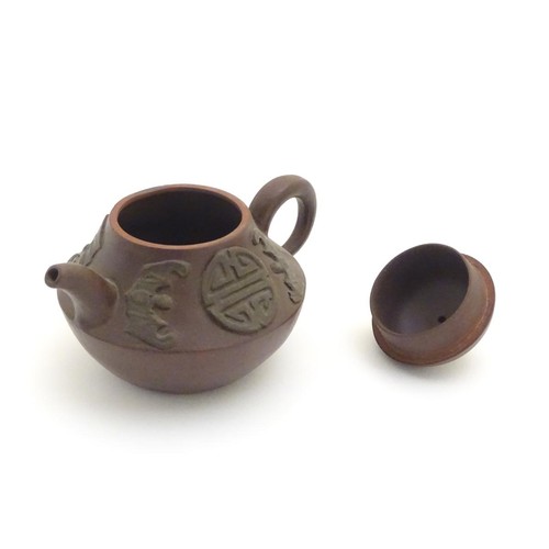 69 - Three Chinese ceramic items comprising a Yixing clay teapot, a blue and white water pot and a model ... 