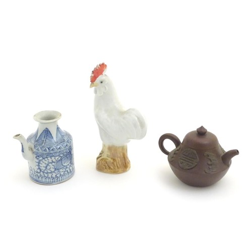 69 - Three Chinese ceramic items comprising a Yixing clay teapot, a blue and white water pot and a model ... 