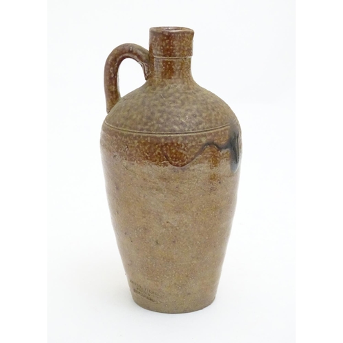 100 - A studio pottery jug with drip glaze, together with a stoneware wine flagon with impressed marks Cam... 