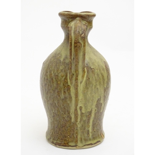 100 - A studio pottery jug with drip glaze, together with a stoneware wine flagon with impressed marks Cam... 