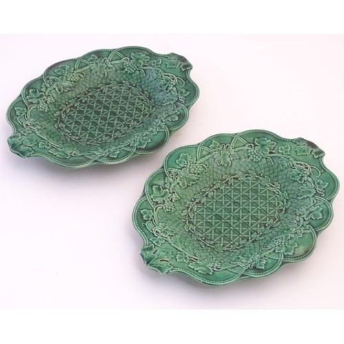 170 - A pair of Wedgwood majolica oval plates with lobed rims and green lustre glaze, decorated with mould... 