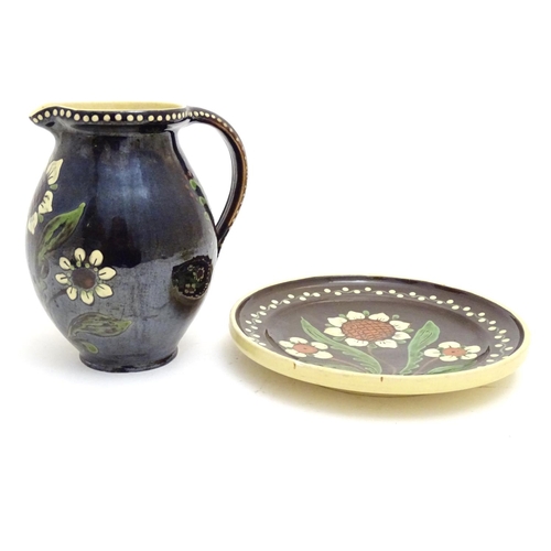 180 - Two items of Continental studio pottery comprising a jug and a plate with floral and foliate detail.... 