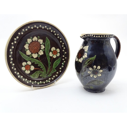 180 - Two items of Continental studio pottery comprising a jug and a plate with floral and foliate detail.... 