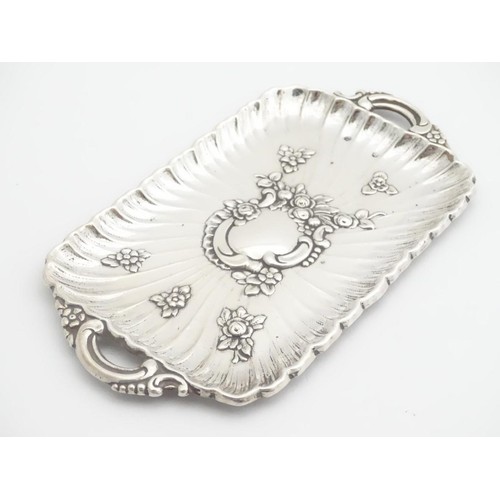 232 - A late 19thC Spanish silver dressing table tray with embossed decoration. 6 1/4