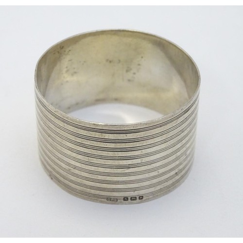 244 - An Art Deco silver napkin ring with banded decoration. Hallmarked London 1945 maker GFB