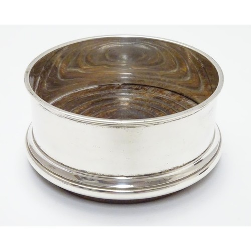 245 - A silver coaster with turned wooden base. Hallmarked Birmingham 1987 maker Argyll Silver. 4