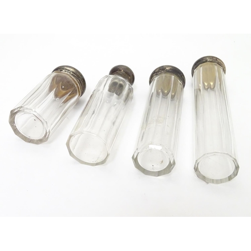 344 - 4 assorted cut glass dressing table bottles with silver tops. The tallest 6 1/2