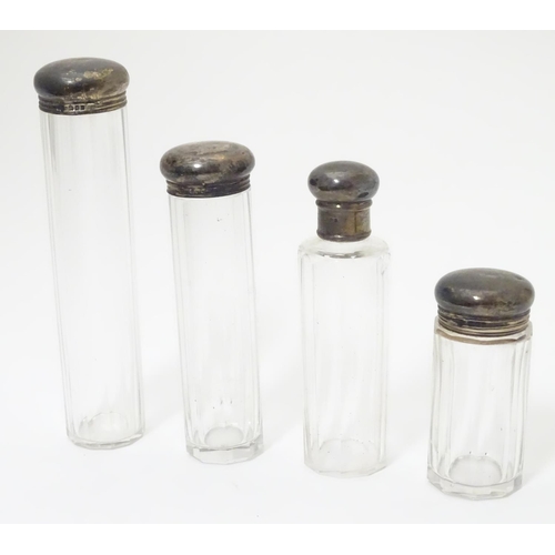 344 - 4 assorted cut glass dressing table bottles with silver tops. The tallest 6 1/2