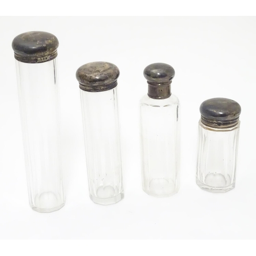 344 - 4 assorted cut glass dressing table bottles with silver tops. The tallest 6 1/2