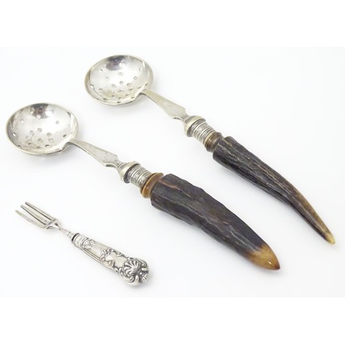 458 - Two silver plate strainer spoons with antler handles, together with a miniature white metal fork. Th... 