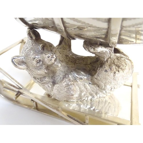 488 - A 21stC novelty silver plated spirit flask, the base formed as a bear laying on a sled supporting a ... 