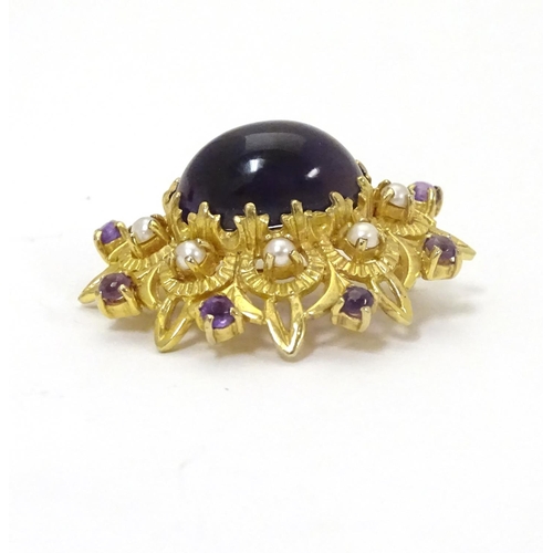 580 - A 9ct gold brooch set with central oval cabochon amethyst surrounded by eight seed
pearls, further s... 