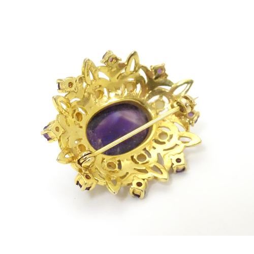 580 - A 9ct gold brooch set with central oval cabochon amethyst surrounded by eight seed
pearls, further s... 