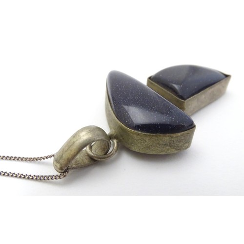 605 - A modernist pendant set with polished hardstone detail 2'' long with a 16'' silver chain.