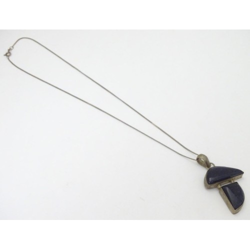 605 - A modernist pendant set with polished hardstone detail 2'' long with a 16'' silver chain.