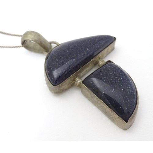 605 - A modernist pendant set with polished hardstone detail 2'' long with a 16'' silver chain.