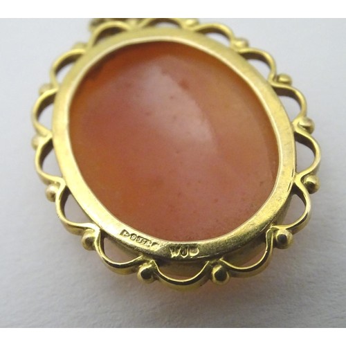 606 - A 9ct gold cameo pendant on a gilt metal chain. The pendant 1 1/2'' long