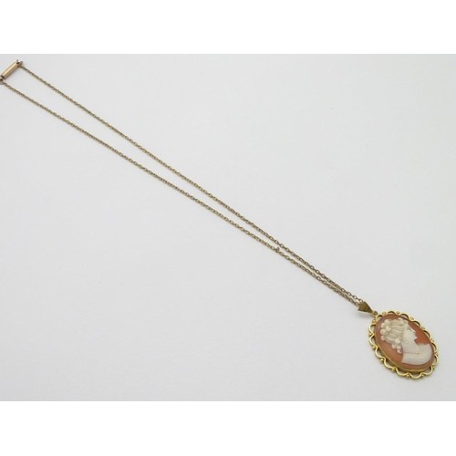 606 - A 9ct gold cameo pendant on a gilt metal chain. The pendant 1 1/2'' long