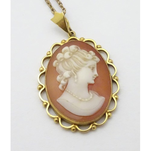 606 - A 9ct gold cameo pendant on a gilt metal chain. The pendant 1 1/2'' long