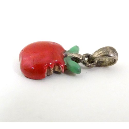 607 - A silver pendant / charm formed as a bitten apple with enamel decoration. ¾'' long