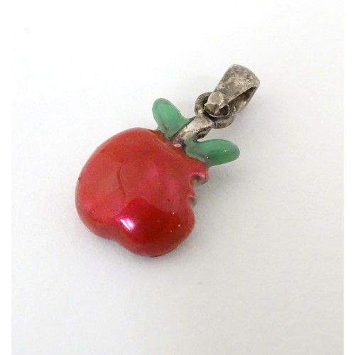 607 - A silver pendant / charm formed as a bitten apple with enamel decoration. ¾'' long