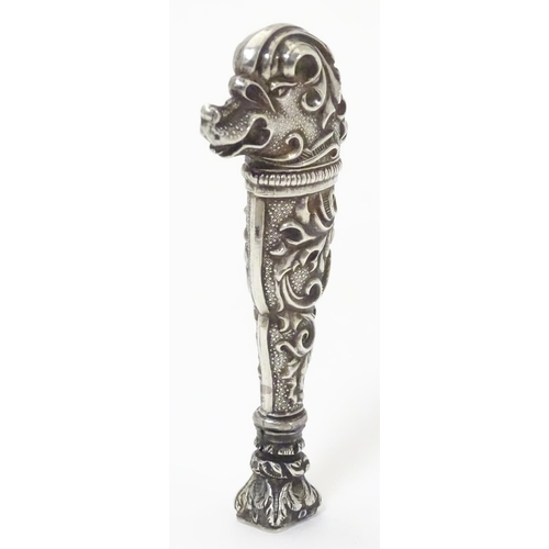 651 - A Continental white metal hand seal formed with stylised dog head decoration and seal under. Approx.... 