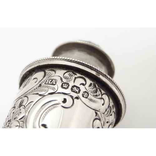 248 - A pair of silver pepper pots with embossed formal and C-scroll decoration, hallmarked Sheffield 1897... 