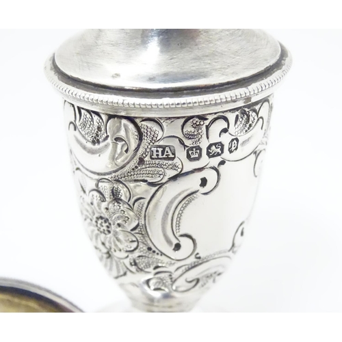 248 - A pair of silver pepper pots with embossed formal and C-scroll decoration, hallmarked Sheffield 1897... 