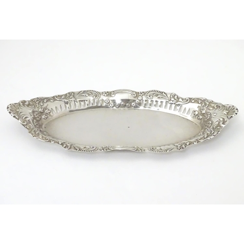 252 - A silver dish of oval form with pierced and embossed decoration , hallmarked Birmingham 1899 maker J... 