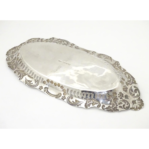 252 - A silver dish of oval form with pierced and embossed decoration , hallmarked Birmingham 1899 maker J... 