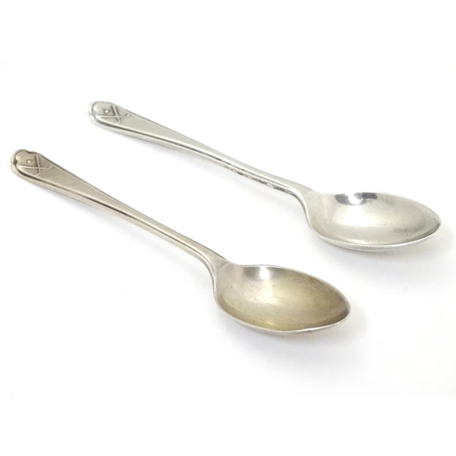 265 - A pair of silver teaspoons with crossed golf club and ball decorations to handles. Hallmarked Sheffi... 