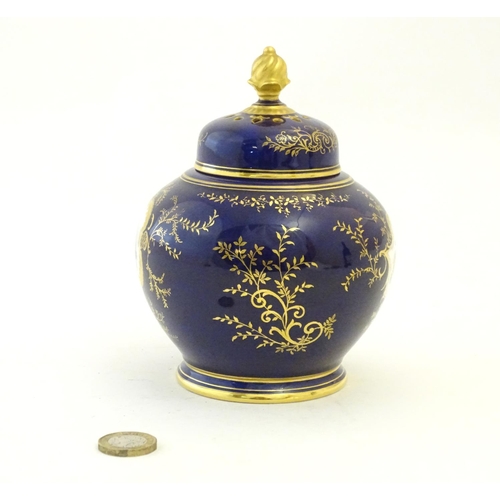 119 - A Coalport pot pourri with a cobalt blue ground with gilt detail and a central hand painted landscap... 