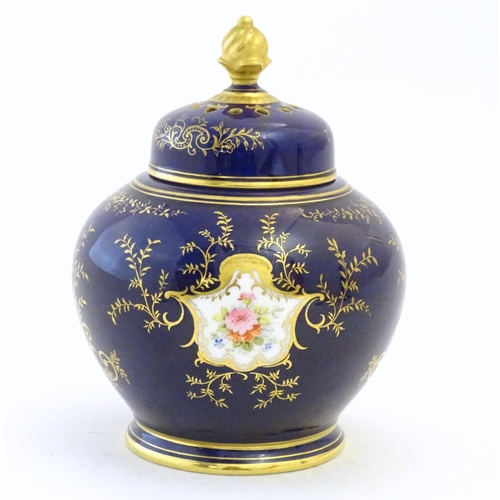 119 - A Coalport pot pourri with a cobalt blue ground with gilt detail and a central hand painted landscap... 