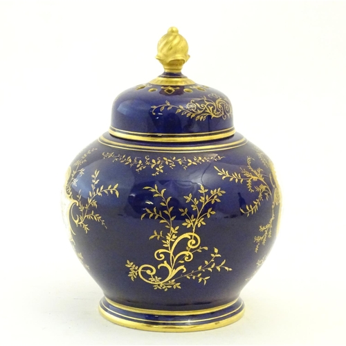 119 - A Coalport pot pourri with a cobalt blue ground with gilt detail and a central hand painted landscap... 