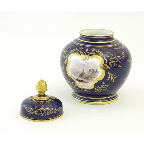 119 - A Coalport pot pourri with a cobalt blue ground with gilt detail and a central hand painted landscap... 